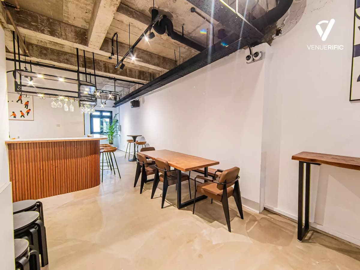 office party event space with rustic bar with wooden furniture and industrial glass hanger